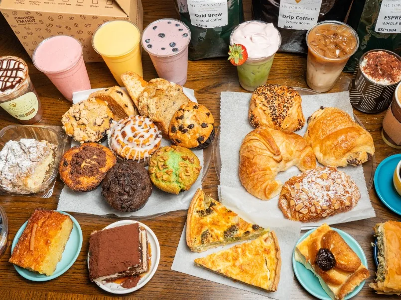 Coffee drinks and fresh pastries spread on a café table